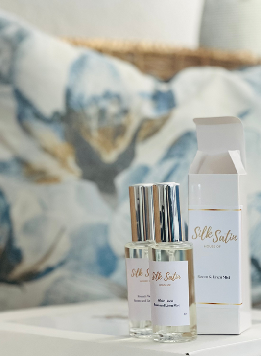Silk Satin skincare products on a white surface with a decorative pillow in the background